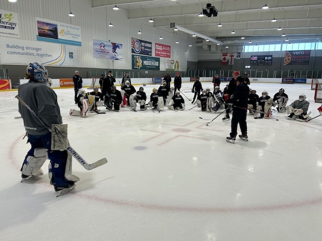 Goalies on the ice with hockey school instructor